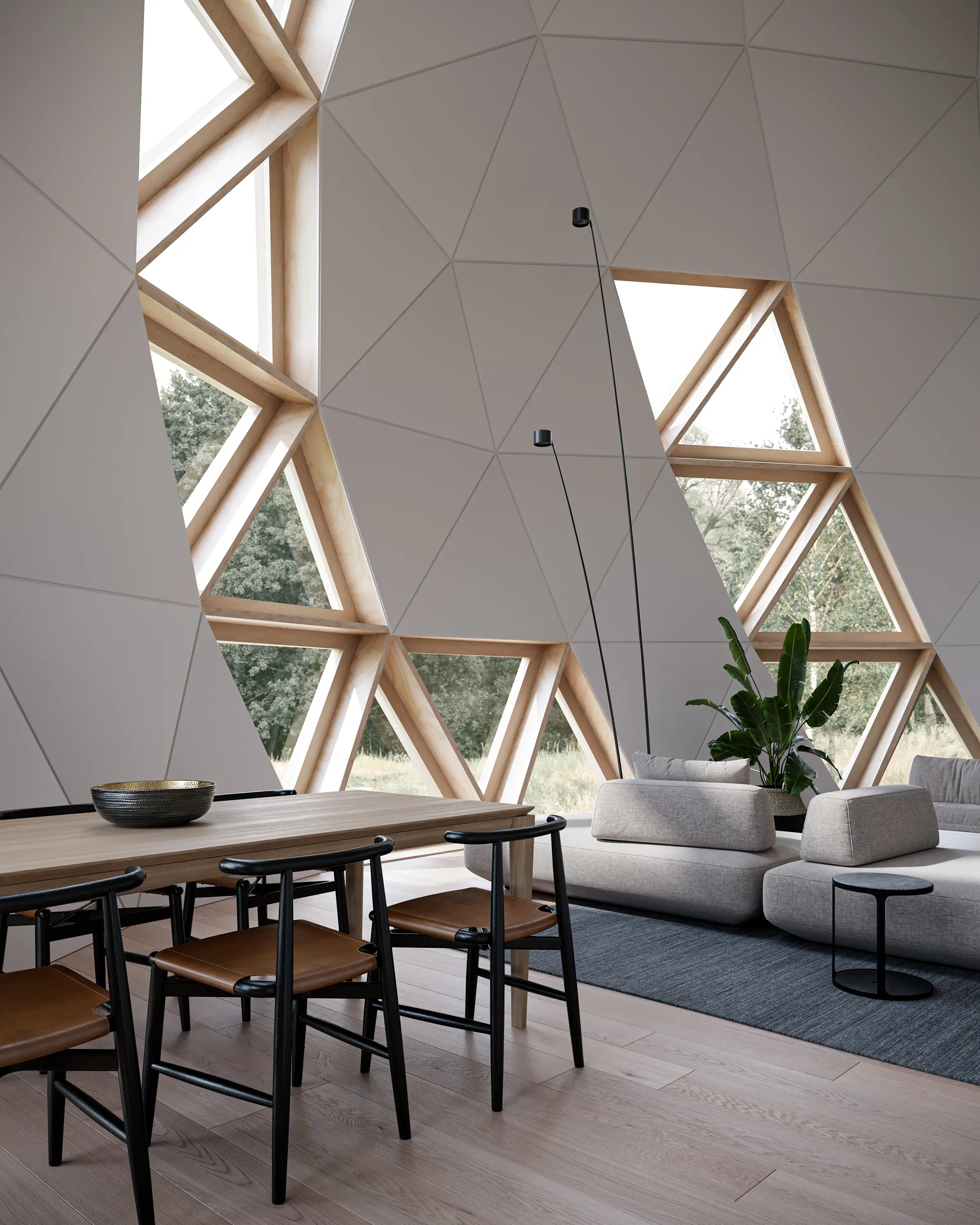 Interior of the Dome House, with triangular timber-framed windows in the geodesic shell above a dining table and low sofas.